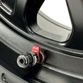 Close-up of a black wheel with red and black valve stem and pull-to-vent label