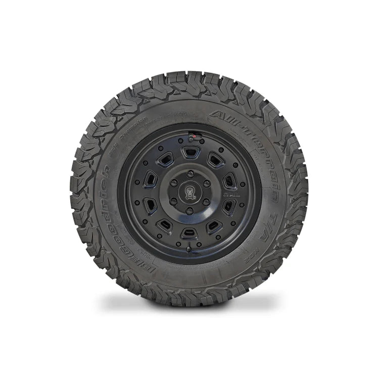 Black off-road tire with rugged tread and multi-spoke alloy wheel viewed from the side.