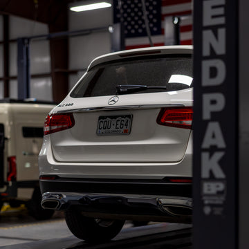 Rear view of a white Mercedes-Benz SUV parked in an indoor garage