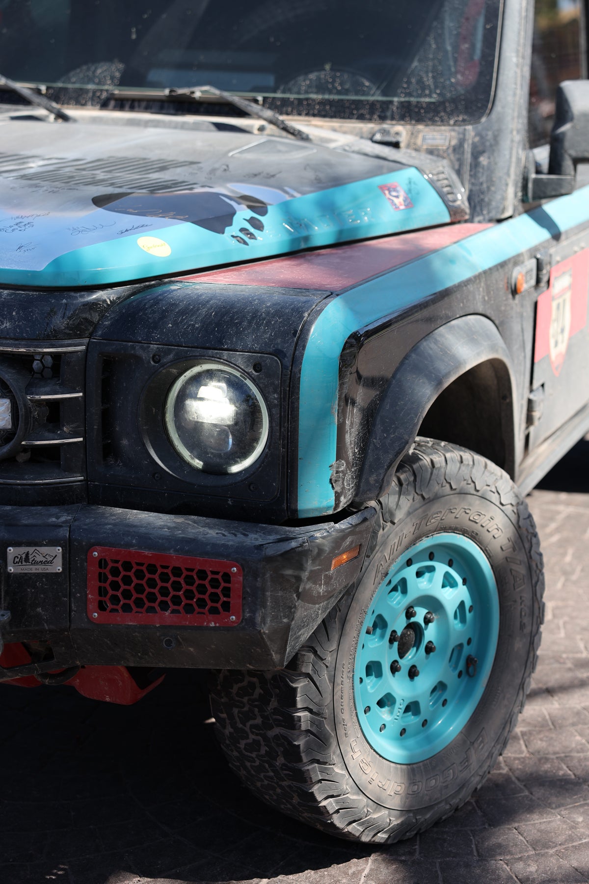 Close-up of a custom black SUV with blue accents and rugged off-road tires