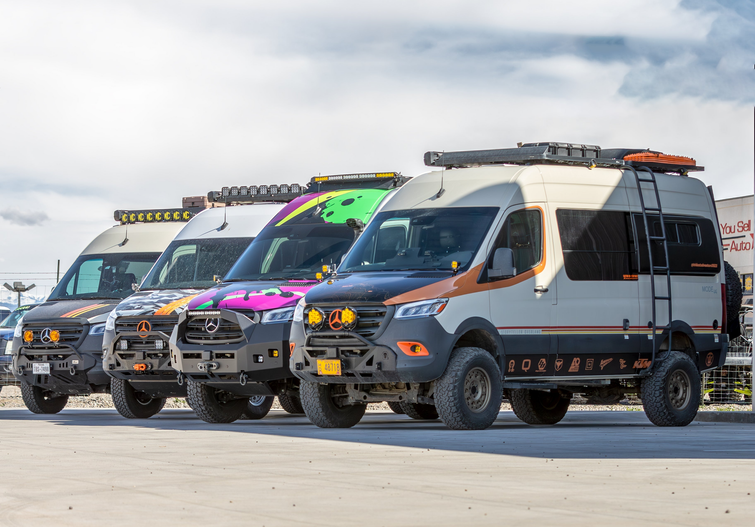 Three customized Mercedes-Benz Sprinter vans parked side by side in an outdoor lot.